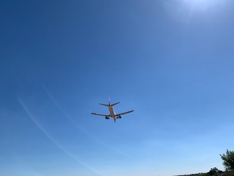 an airplane is flying in the blue sky