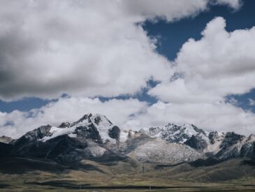 a mountain range with a few clouds in the sky