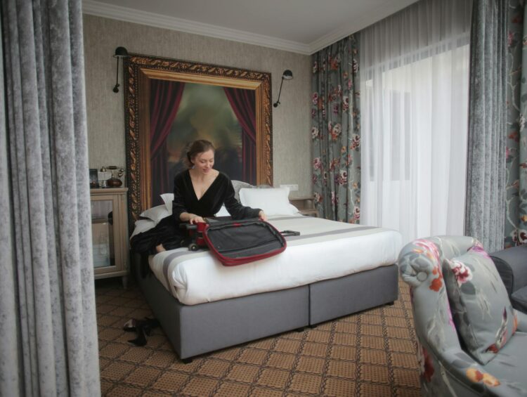 A woman in a chic hotel room packing her suitcase, ready for travel.